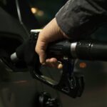Preço da gasolina. Uma mão sujeita uma mangueira de combustível